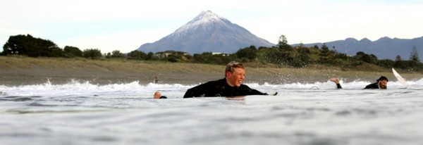 Surf Highway 45 - surfers surfing with beach and mountain the the background